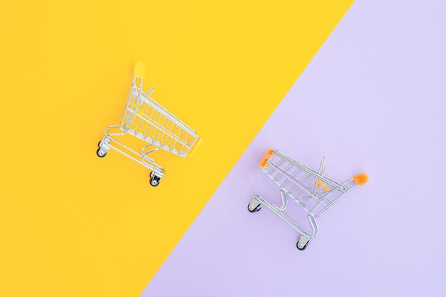 Mini supermarket trolley on violet yellow background