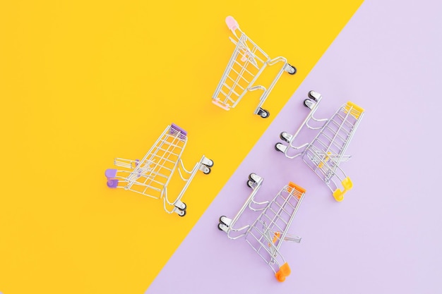 Mini supermarket trolley on violet yellow background