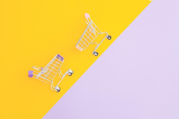 Тележка мини-супермаркета на фиолетово-желтом фоне
