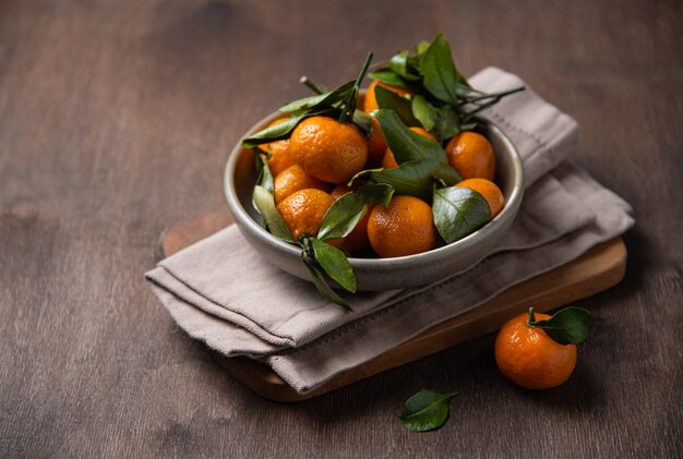 Mini tangerines in a bowl on a wooden old table