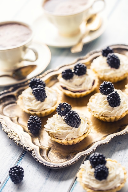 Mini tartlets with blackberries whipped cream and coffee.