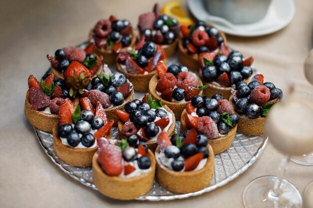 Mini tarts with whipped cream or custard and fresh berries Homemade dessert Copy space