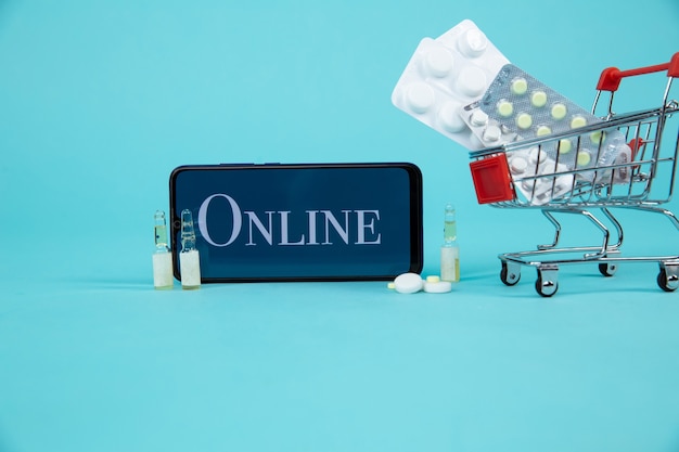 Mini winkelwagentje vol met homeopathische middelen op laptop achtergrond. Homeopathie en internet online shopping concept.