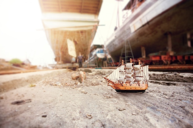 Mini wooden sailboat at shipyard for maintenance.
