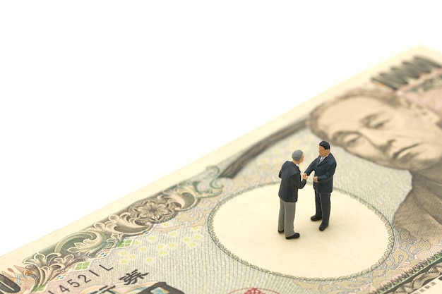 Miniature 2 people businessmen Shake hands Stand on Japanese 