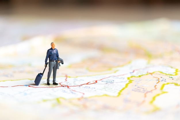 Gente di affari in miniatura in piedi sulla mappa, concetto di viaggio