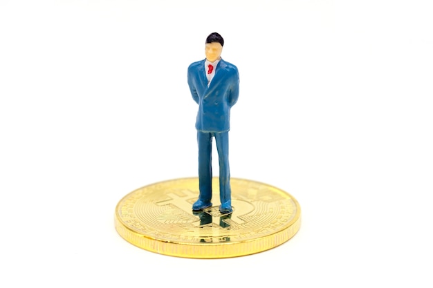 Miniature businessman and Bitcoin on white background