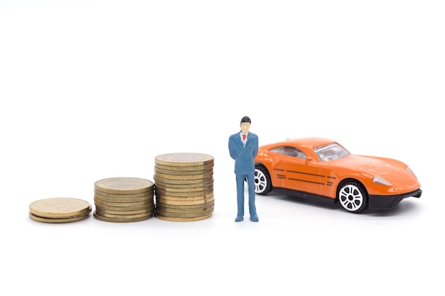 Miniature businessman standing on coins and the car behind. saving and loan concept. 