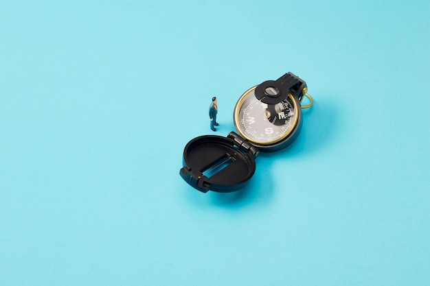 Miniature businessman and vintage compass