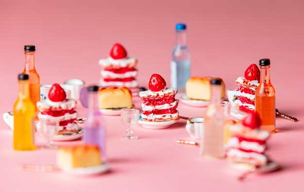 Photo miniature cakes and drink on pink background