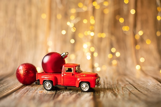 Miniature car on wooden background with christmas light holiday toy decoration sale shopping