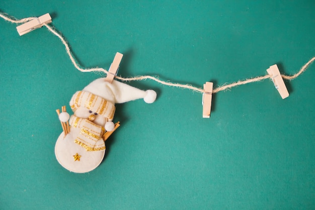 Photo miniature christmas funny toy snowman hanging on the clothespins