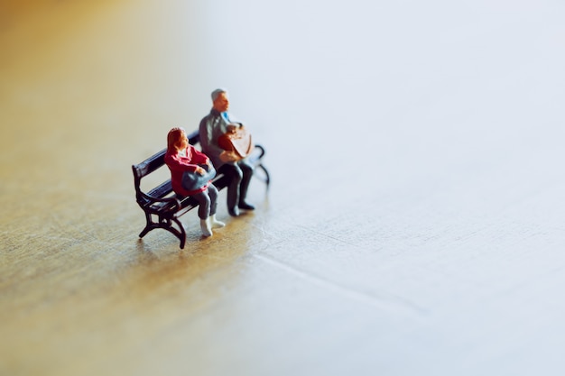 Photo miniature couple sitting together in warm light .