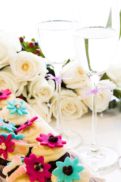 웨딩 파티를 위해 밝은 꽃으로 장식된 미니어처 컵케이크.