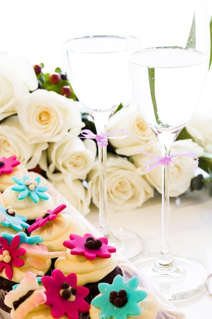 Miniature cupcakes decorated with bright flowers for the wedding party.