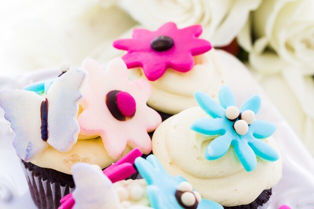 Miniature cupcakes decorated with bright flowers for the wedding party.