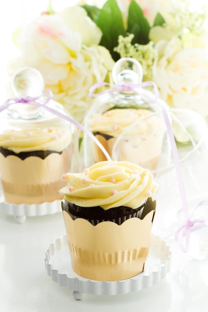 Miniature cupcakes in individual glass stands.
