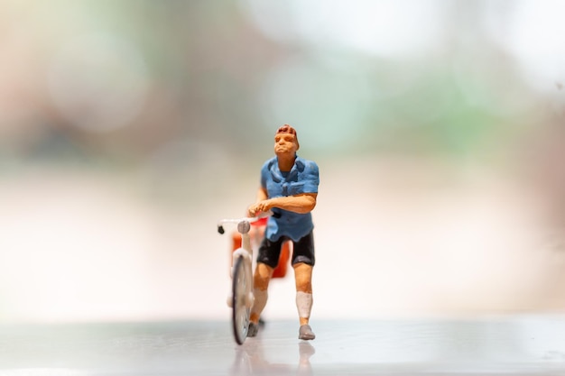 Foto ciclista in miniatura in piedi con la bici giornata mondiale della bicicletta concetto