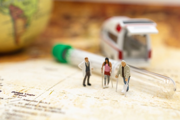 Photo miniature doctor and patient standing with capsule and ambulance. healthcare and medical concepts.