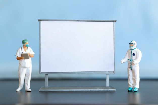 Miniature Doctor standing With Blank White Board