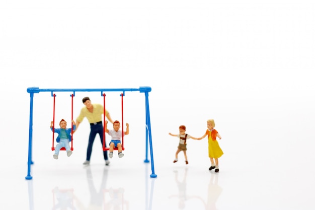 Photo miniature family playing on the swing