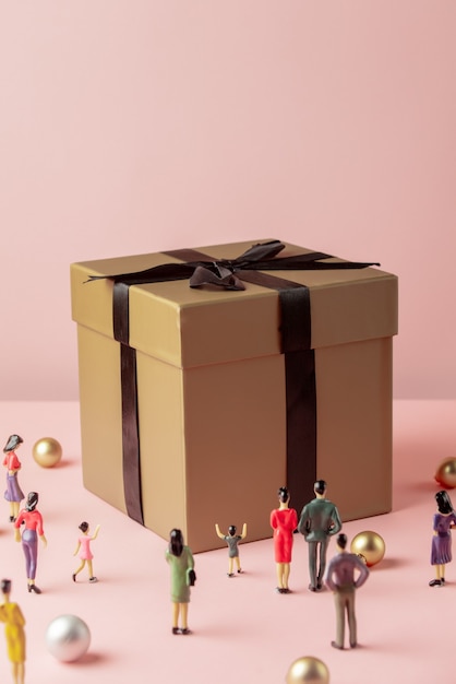 Miniature figures of people and big gift box