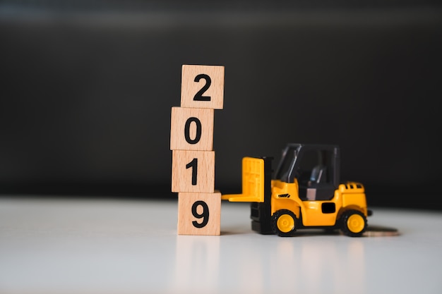 Miniature forklift lift up year 2019 wooden block using as business and industry concept