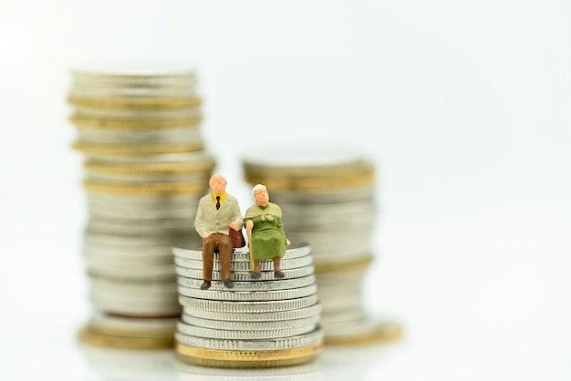 Miniature of Happy old people standing on coins stack