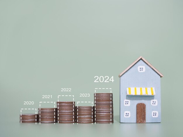 Miniature house stack of coins with virtaul increasing graph The concept of prices for house Property investment House mortgage Real estate in year 2024