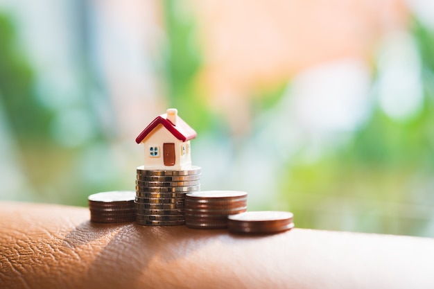 Photo miniature house standing on stack coins