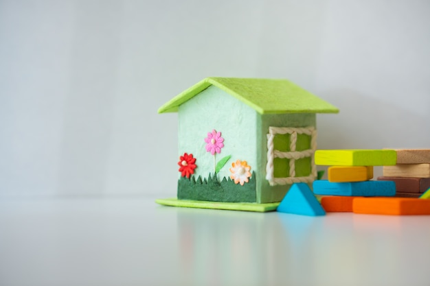 Miniature house with tangram puzzle on white background 