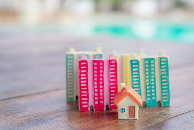 Miniature house on wooden background.