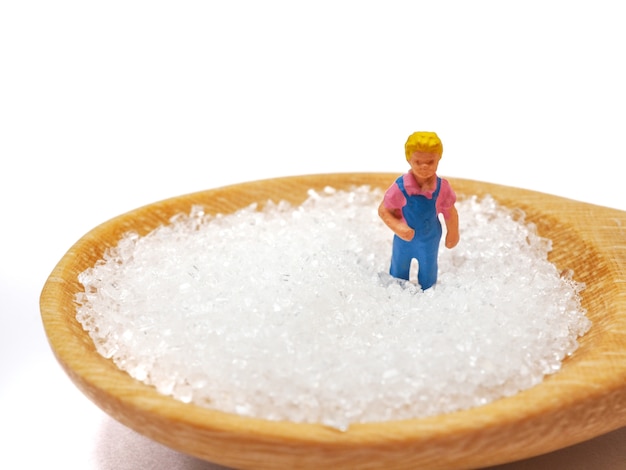 Miniature little child standing on a wooden spoon. health care concept