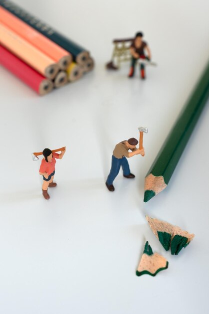 写真 色鉛筆を切るミニチュアの男性と女性の木こり
