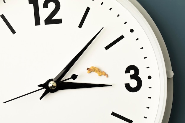 Photo miniature man sleeping on the clock