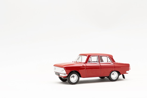 Miniature model of a red retro car on a white surface