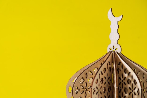 Cupola della moschea in miniatura in legno con sfondo giallo spazi bianchi per il testo ramadhan kareem
