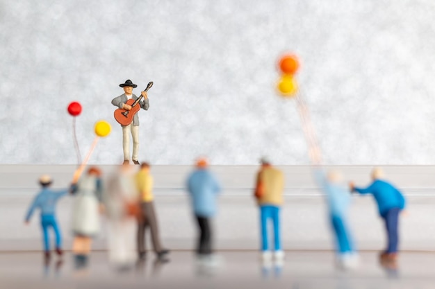 Miniature Musician playing a guitar on stage World music day concept