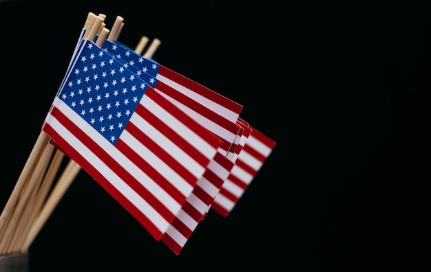 Фото Миниатюрный бумажный флаг сша. американский флаг на черном фоне.