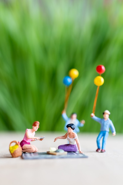 Foto persone in miniatura, una bella coppia di donne lesbiche che si divertono nel parco con i bambini