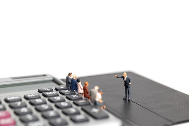 Miniature people : Business man meeting on calculator isolated on white background 