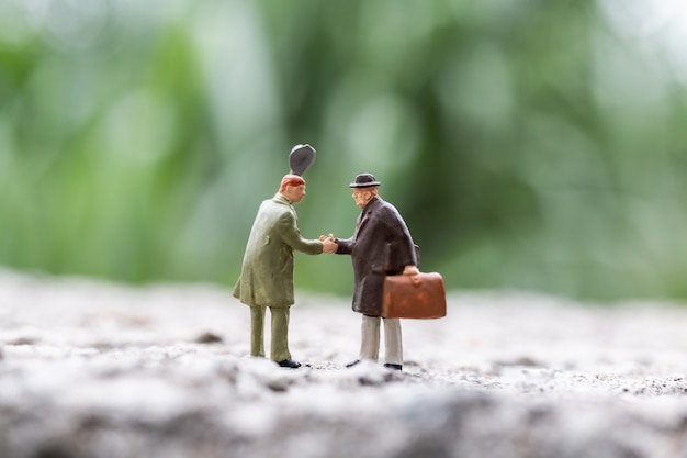 Miniature people:  Business people meeting greeting shaking hands outdoor scene