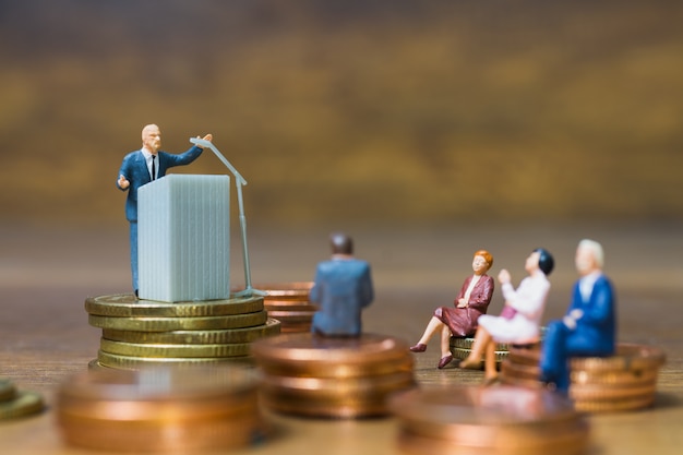 Miniature people: Businessman speaking on the podium