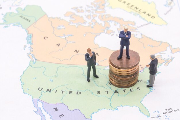 Miniature people, businessman standing on map American 