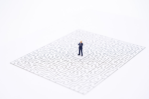 Miniature people businessmen standing in the center of the maze. Business Idea 