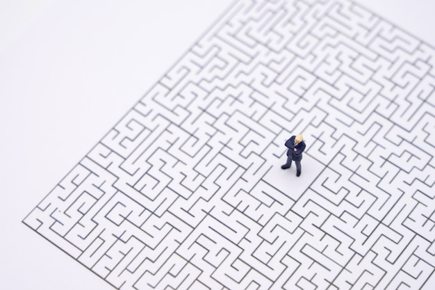 Miniature people businessmen standing in the center of the maze. Business Idea 