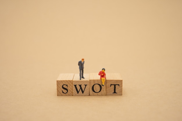 Photo miniature people businessmen standing with wood word swot