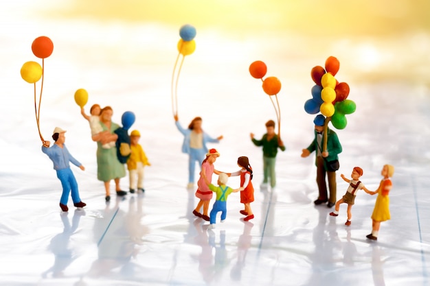 Miniature people: Children playing with ballon.