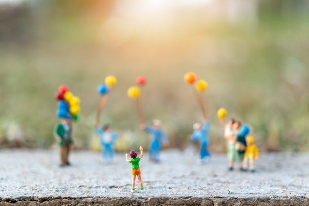 Miniature people concept with Happy family  with balloons 