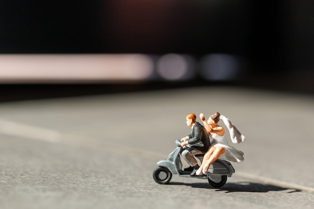 ミニチュアの人々、バイクに乗る愛のカップル